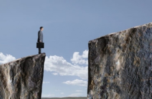 Businessman Standing At Edge Of Cliff